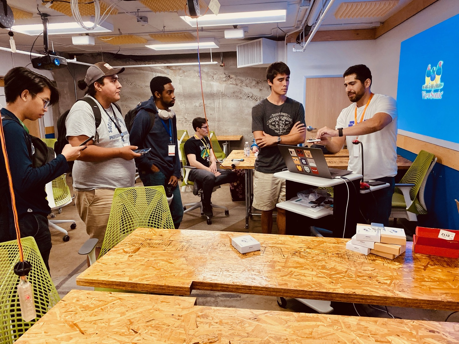 A group of people around a laptop at a hardware meetup
