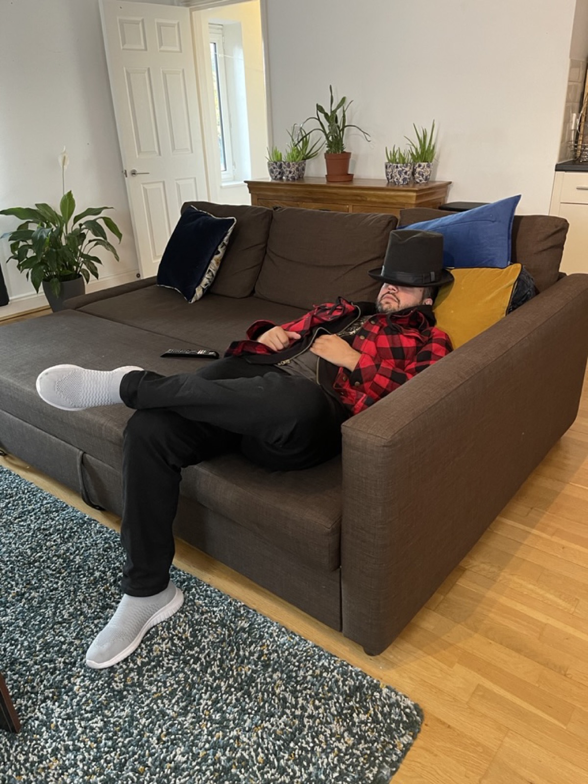An engineer asleep on a sofa in a top hat
