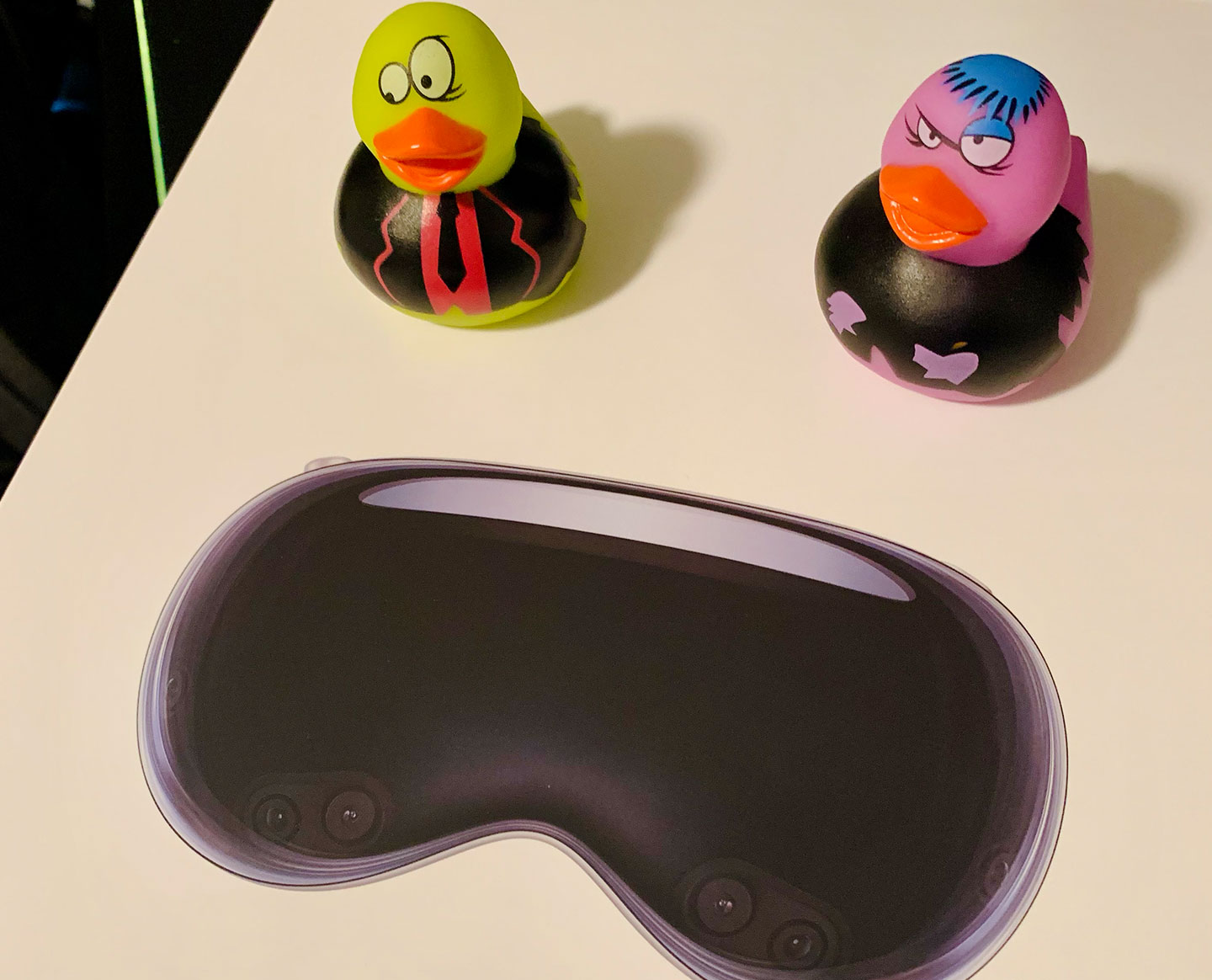 Two rubber ducks in front of a Vision Pro headset