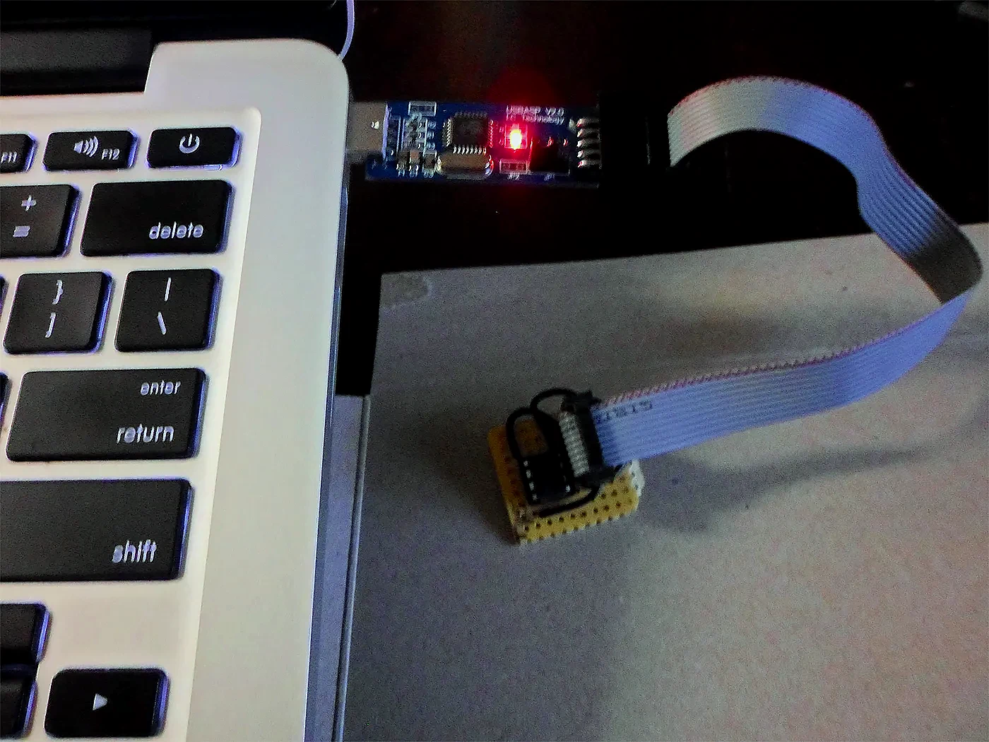 A USB programmer flashing a small circuit board